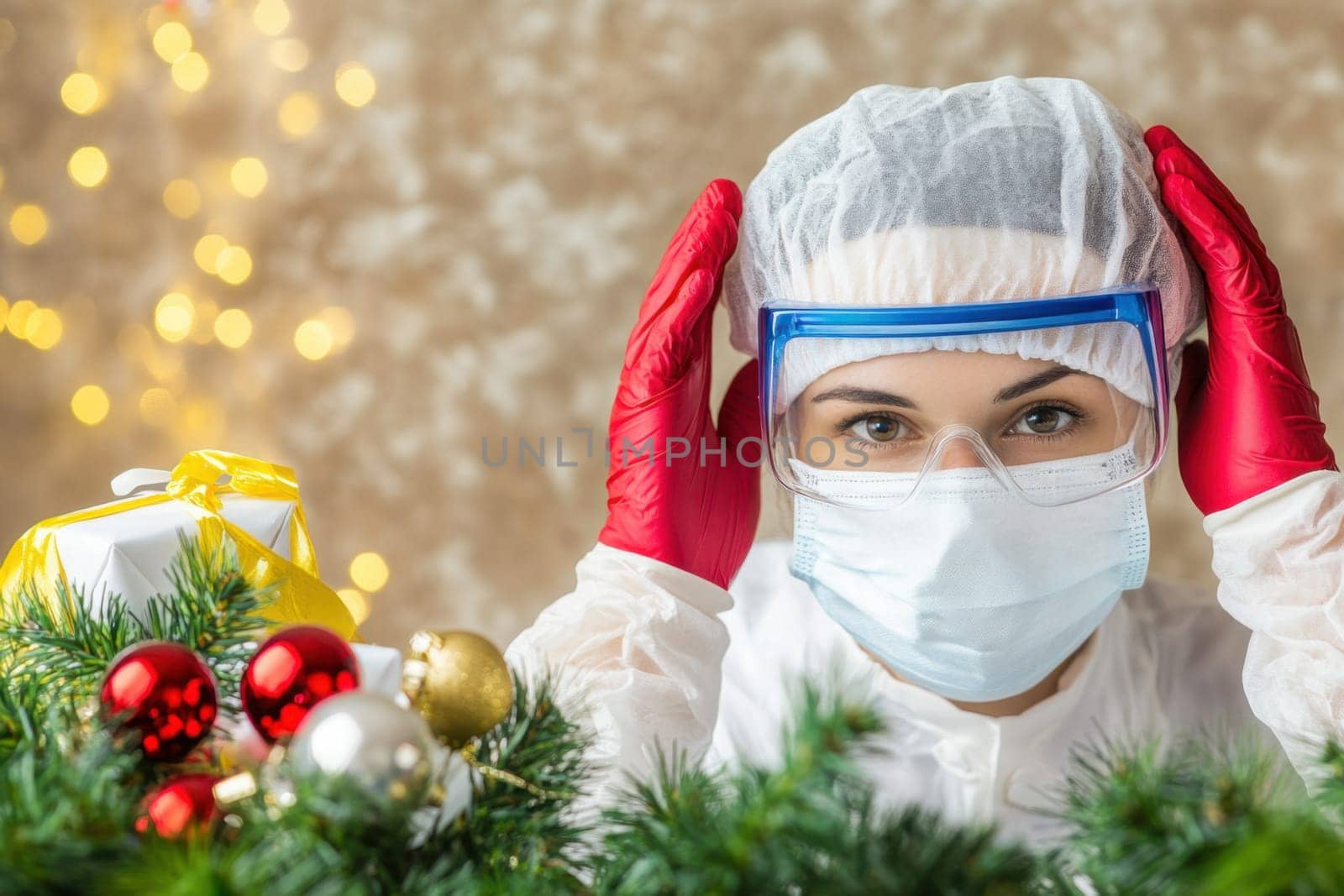A health worker in protective gear stands amid Christmas decorations symbolizing safety during holiday gatherings in a warm atmosphere.