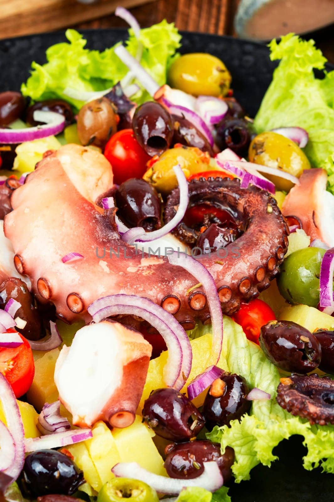 Appetizing salad of octopus, potatoes, olives and greens. Copy space.