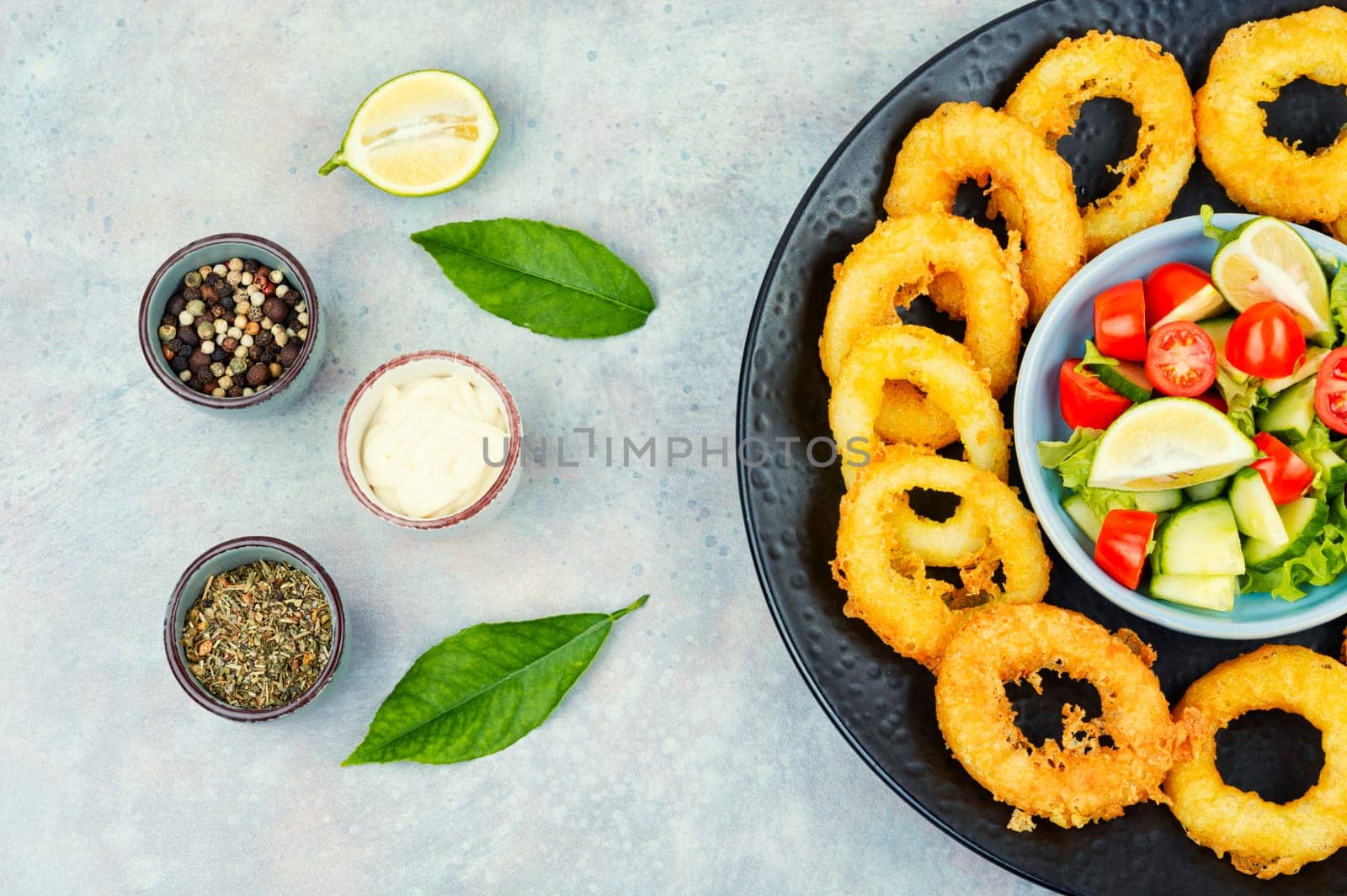 Calamari, fried squid rings with raw vegetable salad. Rustic style.