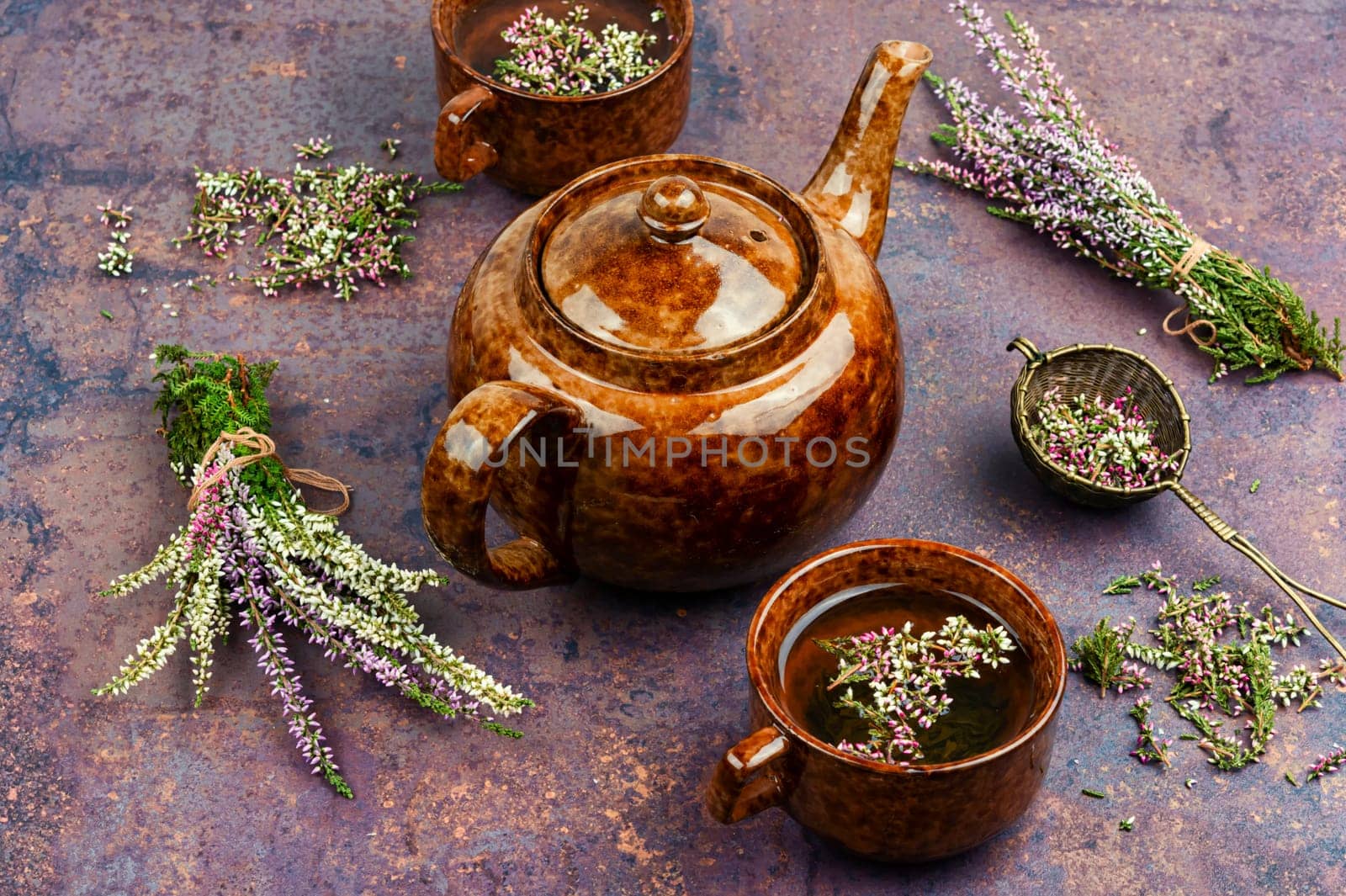 Heather herbal tea in a glass mug and forest herbs on a table. Tea from autumn herbs. Phytotea.