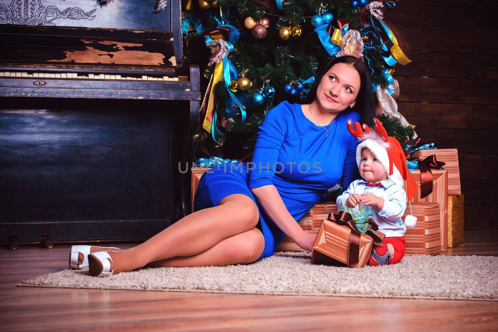 A cheerful mother and her child are joyfully enjoying a precious holiday moment together by the festive tree