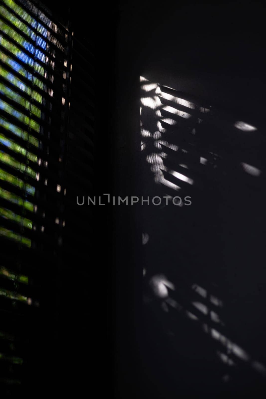 Shadow of the rays falling on the wall through the louvers.