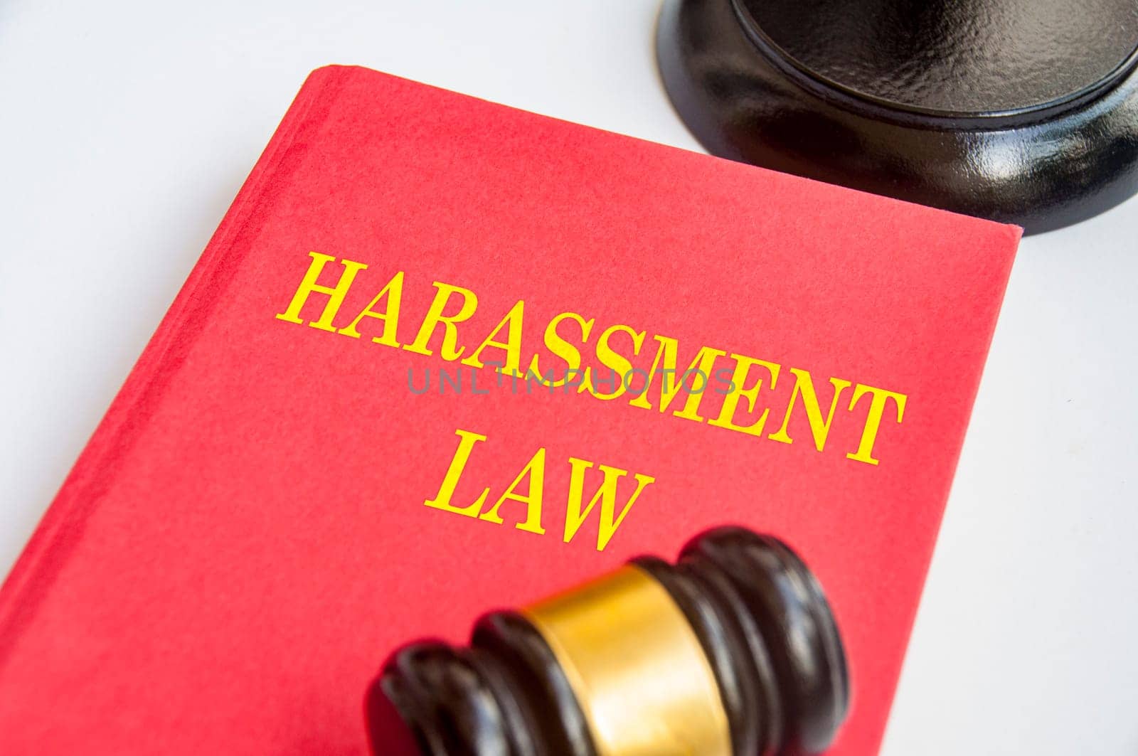 Side view of Harassment Law book with gavel on white background. Zero harassment concept.