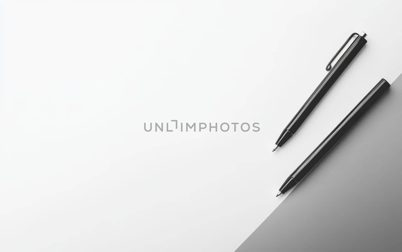 Two sleek black pens on a white and gray background with ample copy space, perfect for business, writing, or design concepts.
