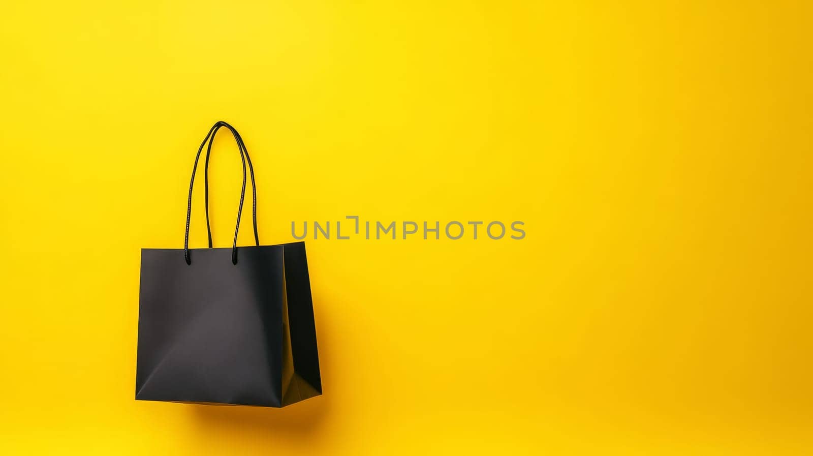 A single black shopping bag on a bright yellow background, ideal for retail design with copy space. Black Friday sale concept with empty place for text.