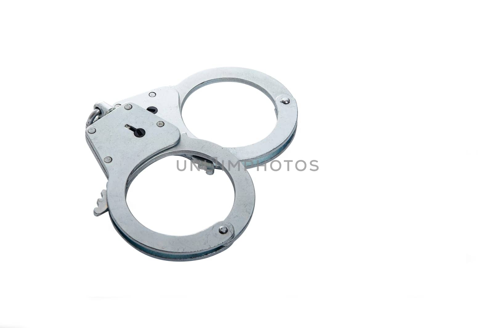 Metal handcuffs on a white isolated background, copy space. High quality photo