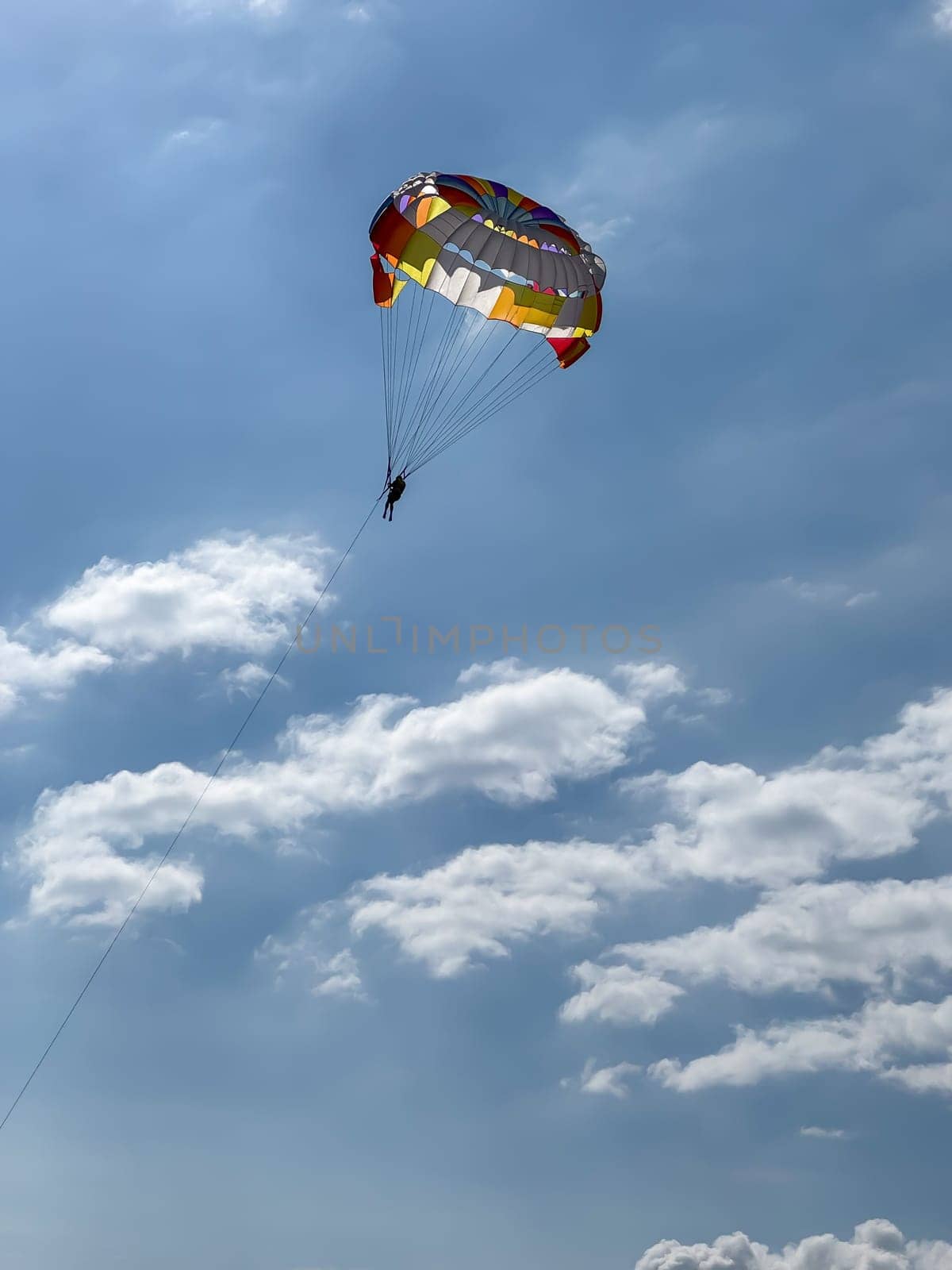 Parasailing in a clear blue sky with clouds. High quality photos