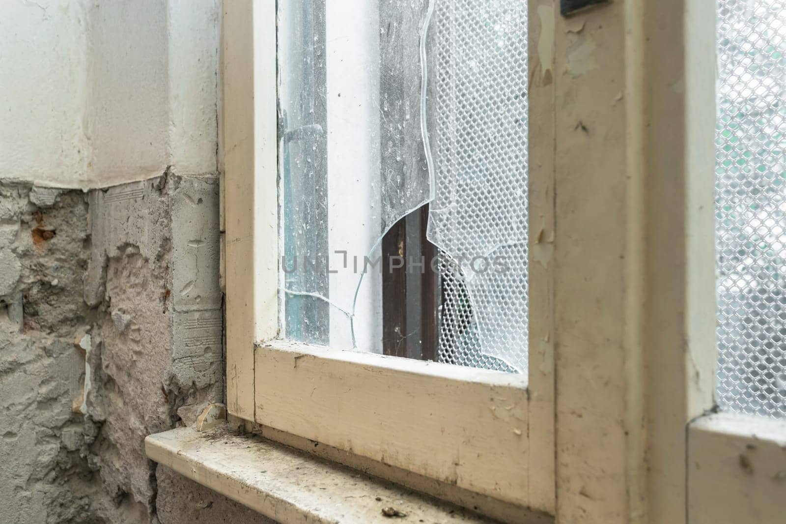 Old abandoned building. Glass of old window broken. Abandoned house. Peeling walls of the room.