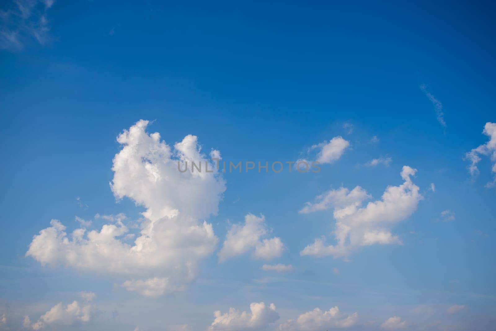 Fluffy white clouds on clear blue sky background with top copy space