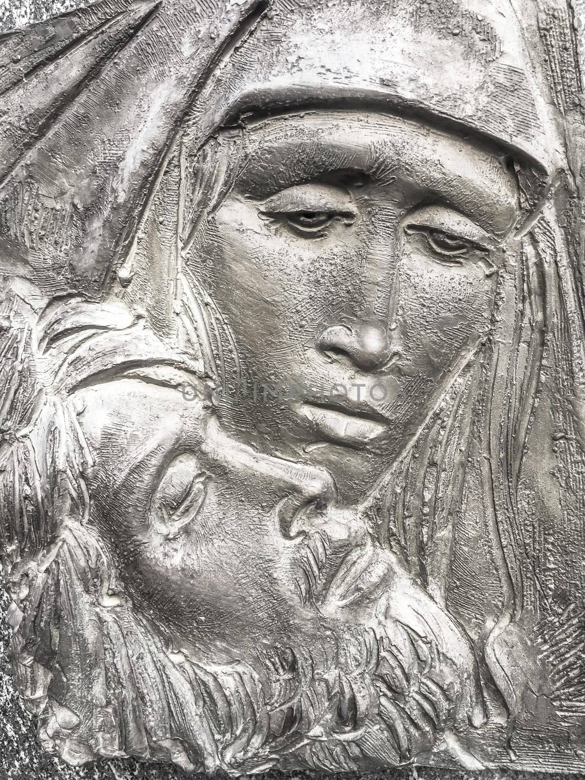 Jesus and Mary. Bronze bas-relief of Mother Mary holding her son Jesus.