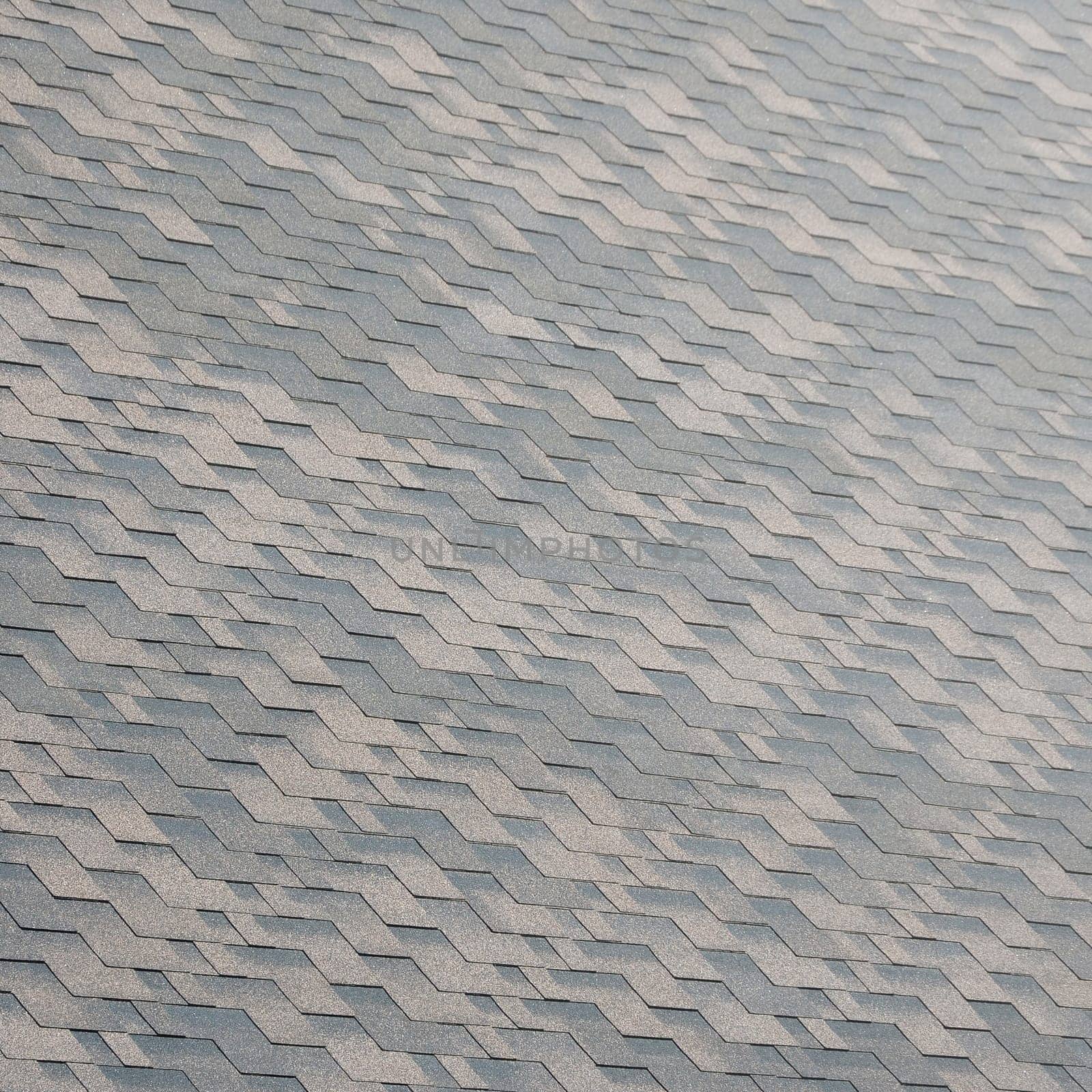 Flexible shingles of bitumen roofing surface. Background mosaic texture of flat roof tiles with bituminous coating