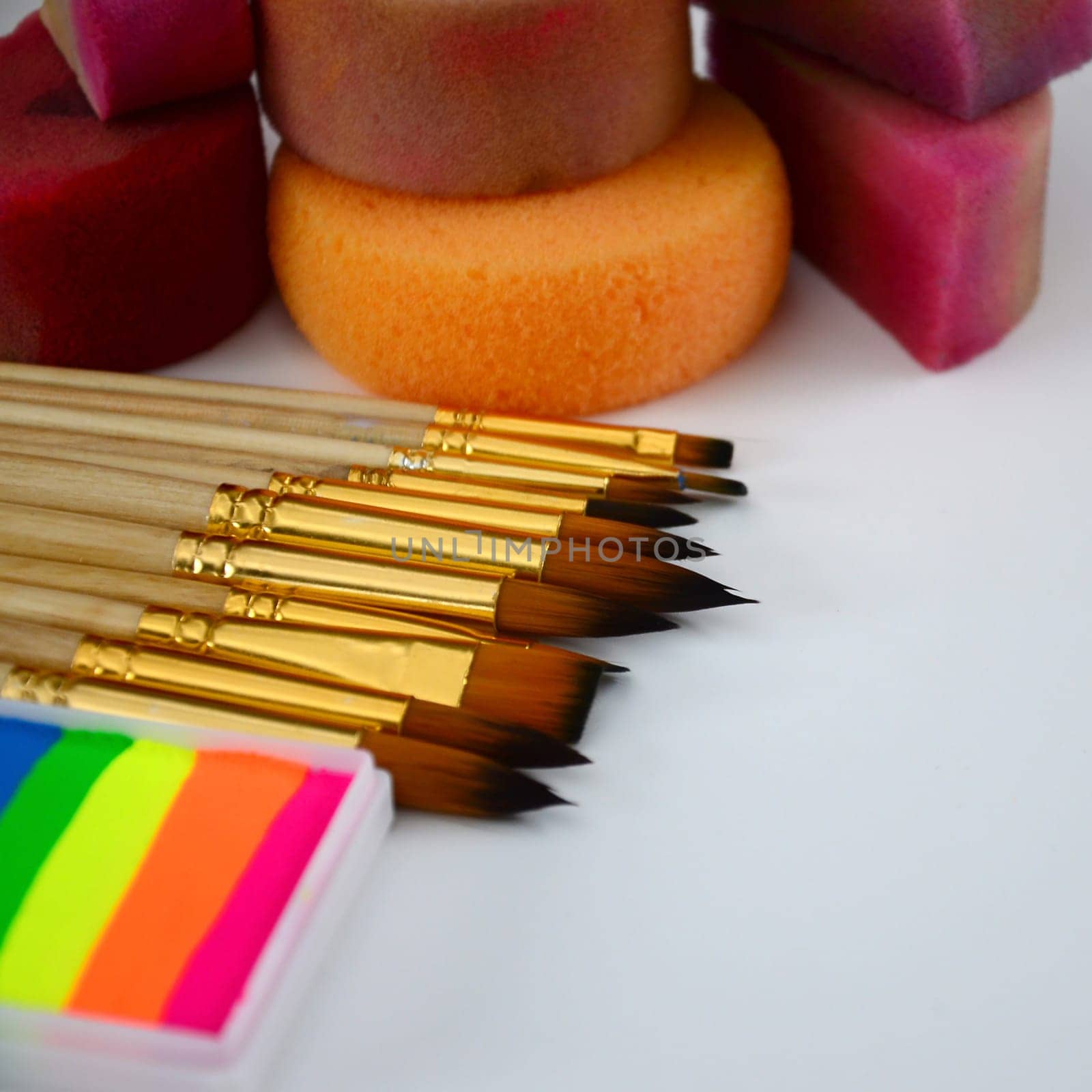 Color cosmetics, brushes and sponges for face painting on white background. Children party concept