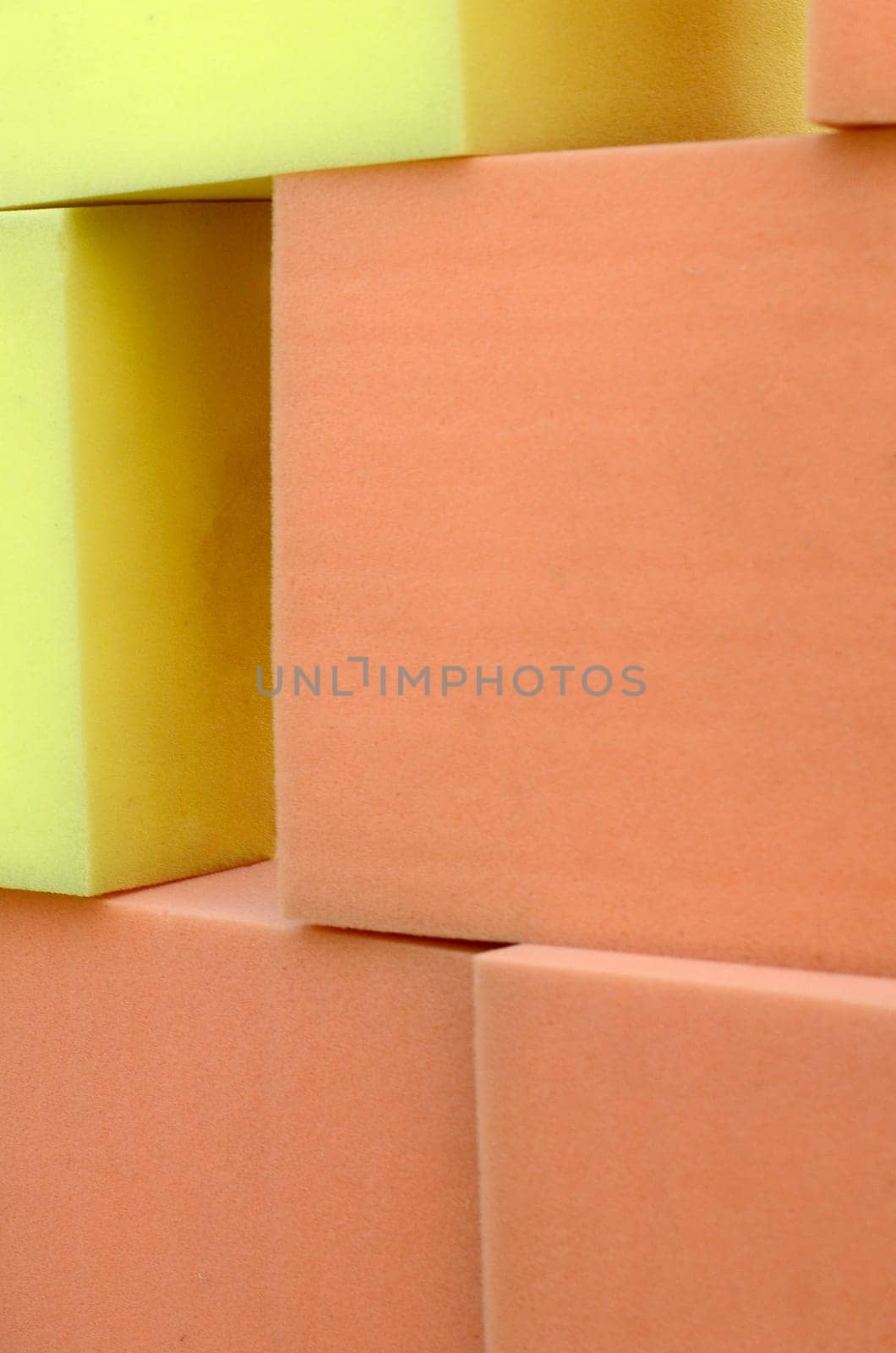 Wall of yellow and red paralon soft cubes in dry pool, trampoline in the childrens gaming center