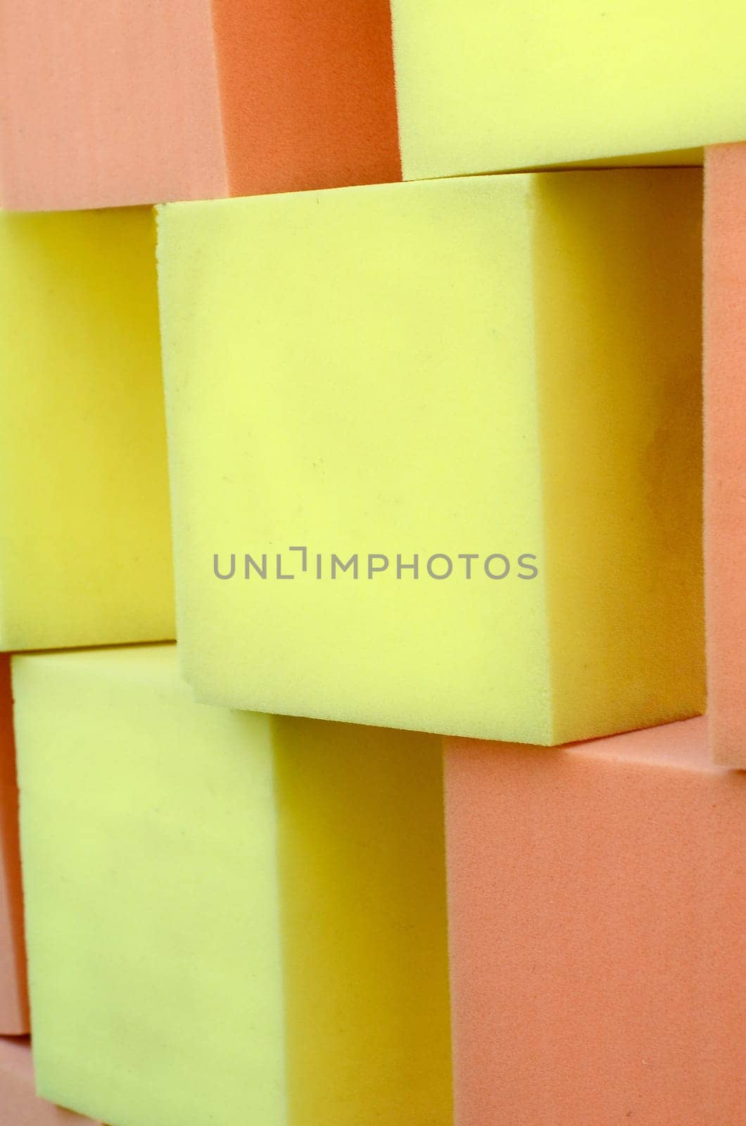Wall of yellow and red paralon soft cubes in dry pool, trampoline in the childrens gaming center