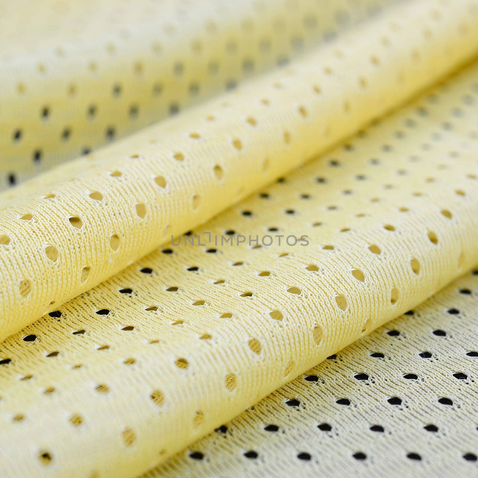 Yellow mesh sport wear fabric textile pattern background. Yellow color football jersey clothing fabric texture sports wear. Breathable porous poriferous material air ventilation with small holes