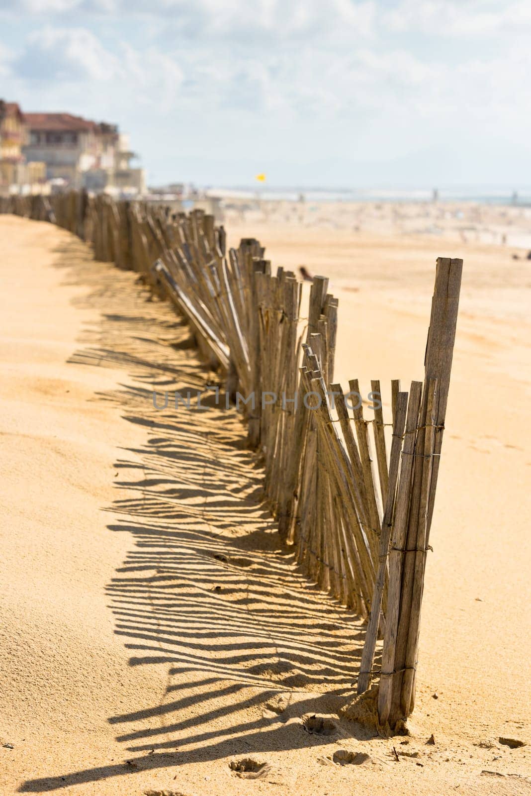 Wooden fence on an Atlantic beach in France, The Gironde Department. Shot with a selective focus