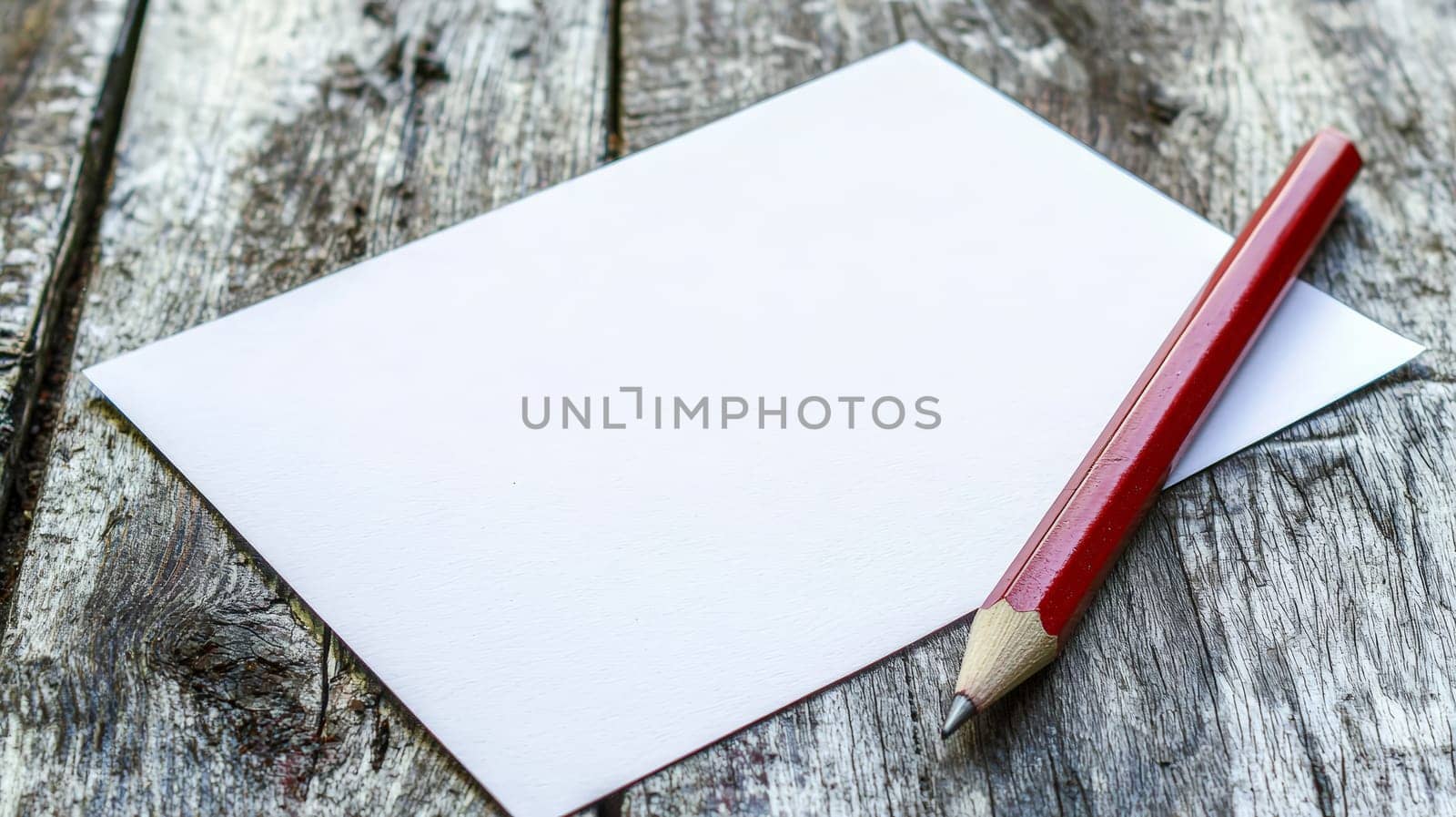 A simple yet evocative scene of a pencil resting beside a blank white sheet of paper on a wooden table. This minimalist setup symbolizes creativity, inspiration, and the endless possibilities that arise from a blank page, ready for ideas to be brought to life.