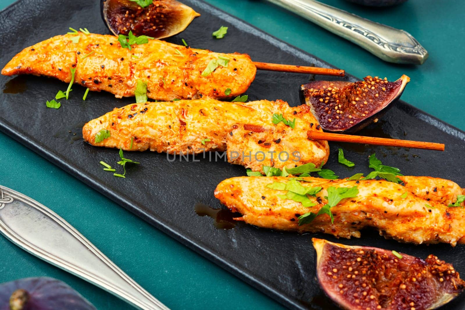 Tasty and colorful chicken meat skewers with figs on a plate. Delicious summer lunch.