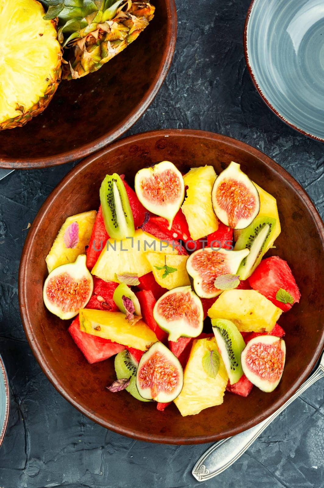 Fruit salad with pineapple, watermelon, kiwi and figs.