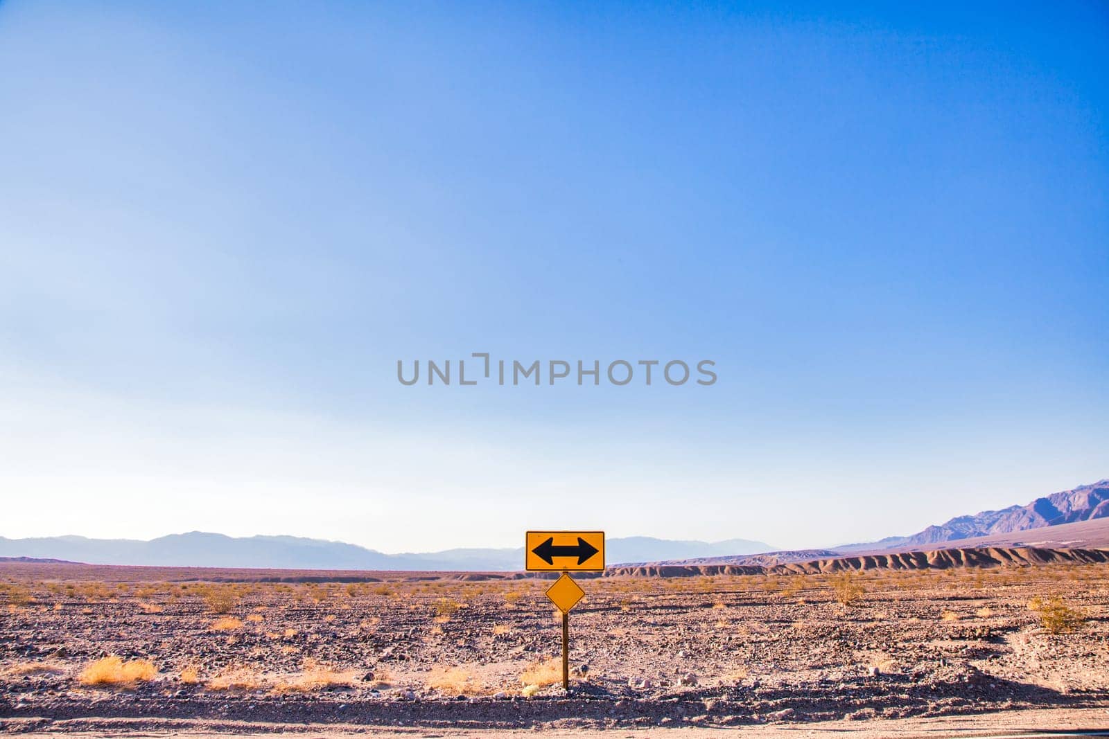 Direction sign in the desert under a blue sky. Concept of uncertain, risk, choice, decision, problem