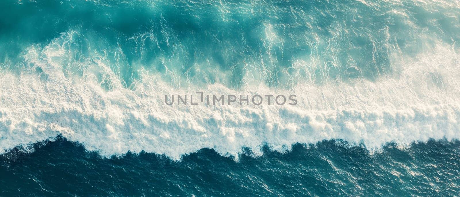 Stunning aerial perspective of turquoise ocean waves crashing with white foam, showcasing the power and beauty of nature.