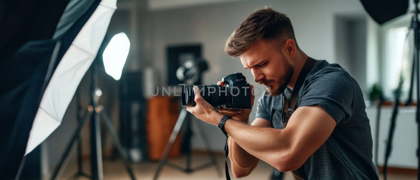 Concentrated photographer adjusting professional camera in a photo studio with lighting equipment, demonstrating expertise in photography and visual arts.