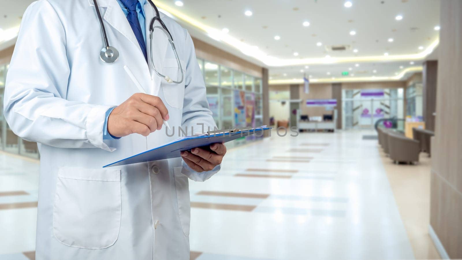 Healthcare and medicine, Writing medical record diagnosis, Doctor with stethoscope in white coat holding clipboard standing on the background inside a hospital,  Close up, Concept of treating disease.