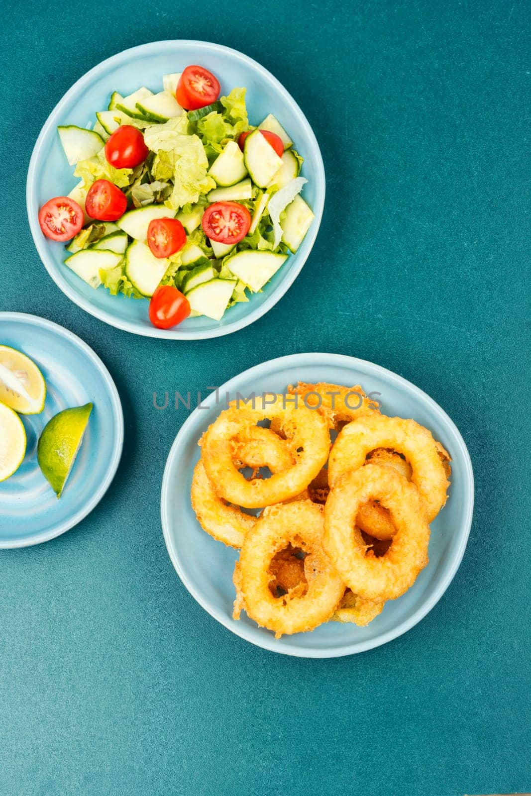 Delicious Fried squid rings and fresh vegetable salad. Close up.