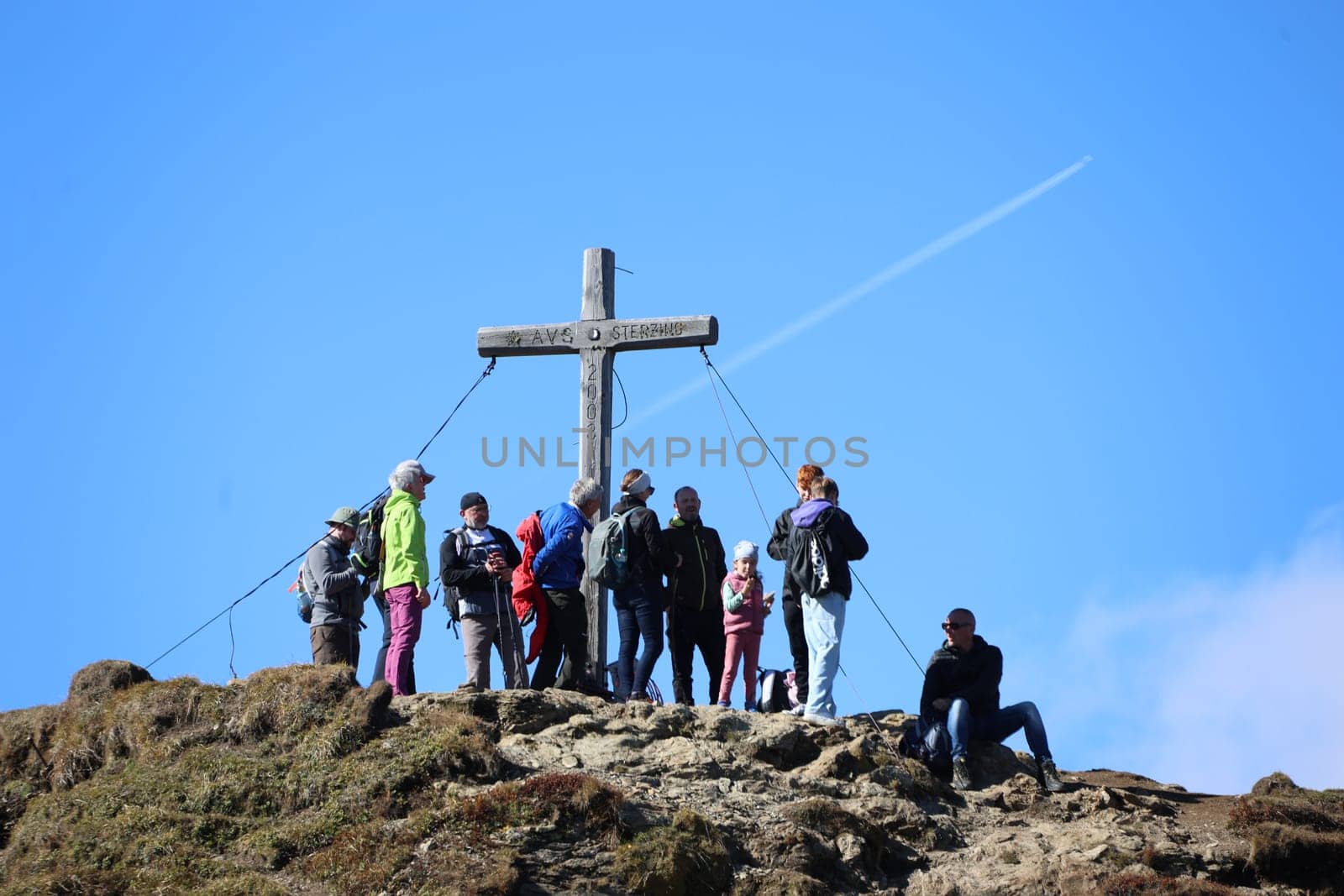 Mountain hikers at the summit cross of the Monte Cavallo in the hiking paradise and holiday region of South Tyrol / Alto Adige above Vipiteno