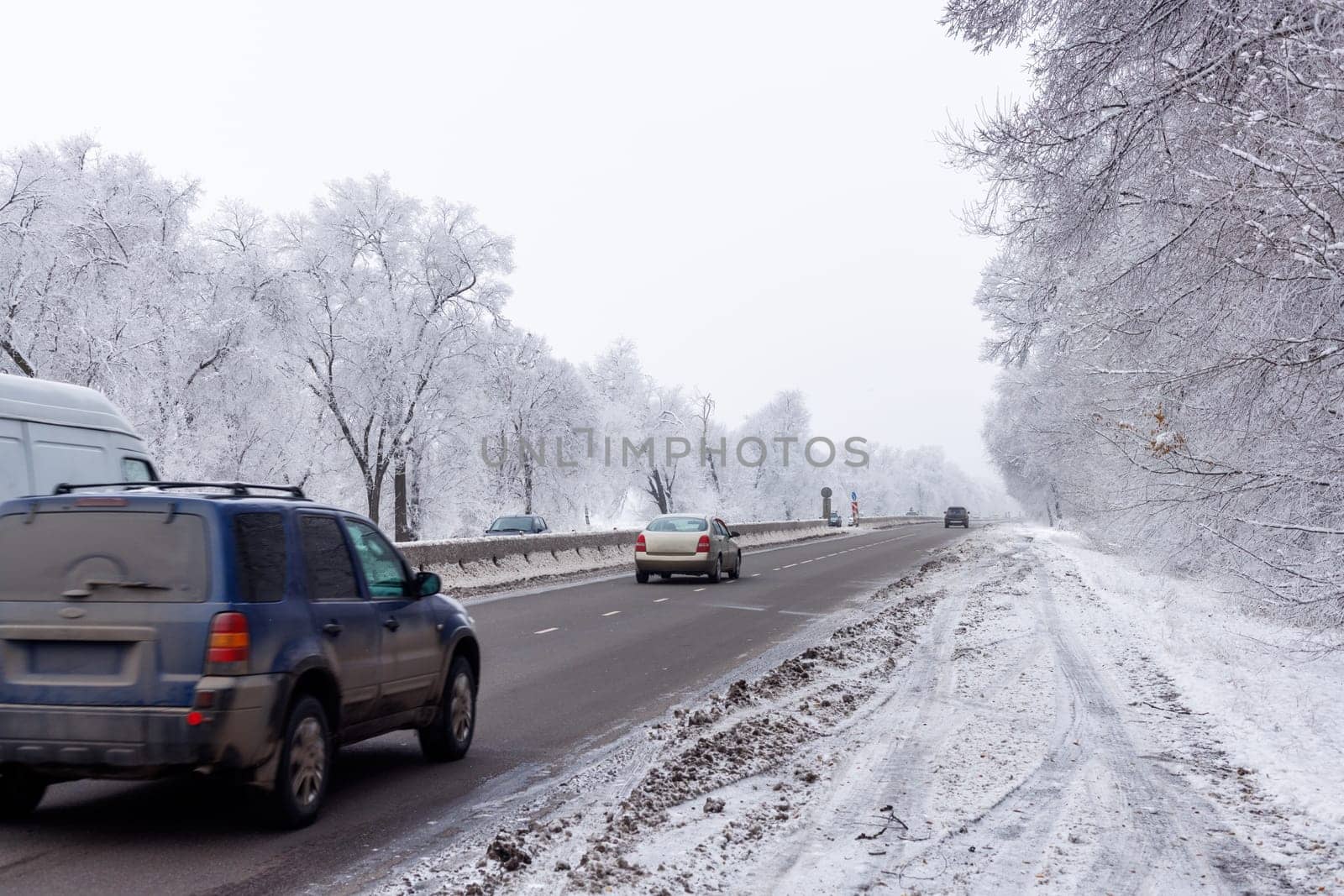 winter interstate road with snow covered trees at overcast day.
