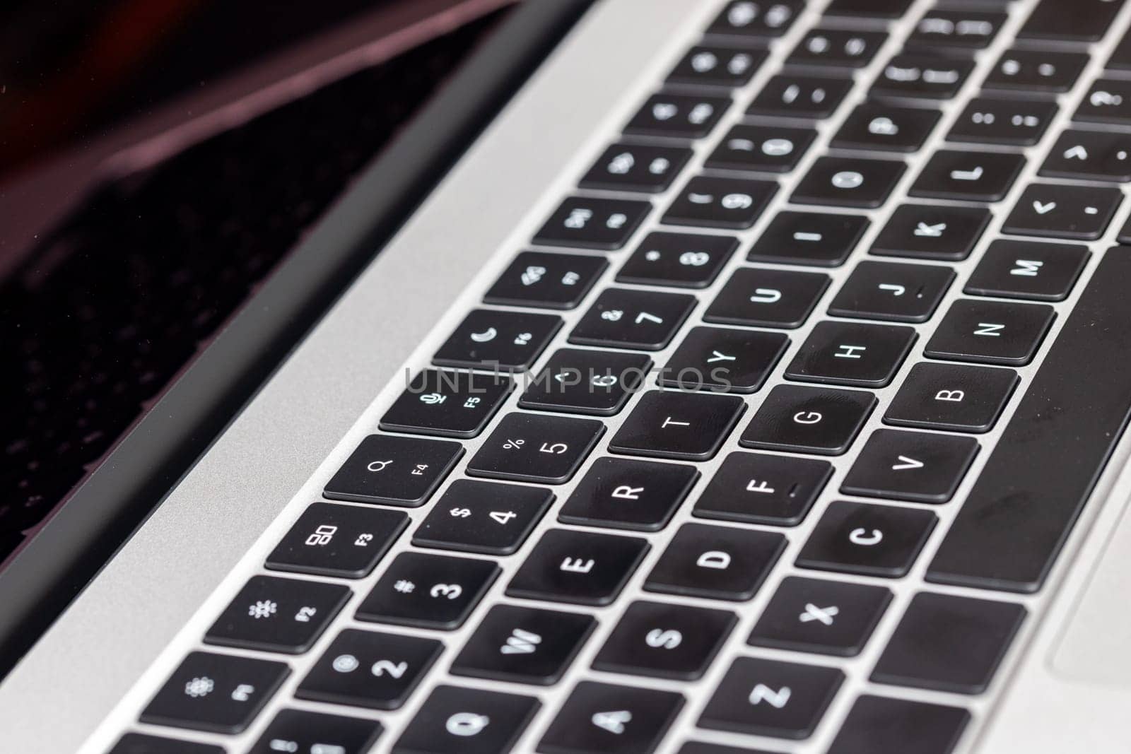 keyboard of famous silver colored laptop with fingerprints, closeup