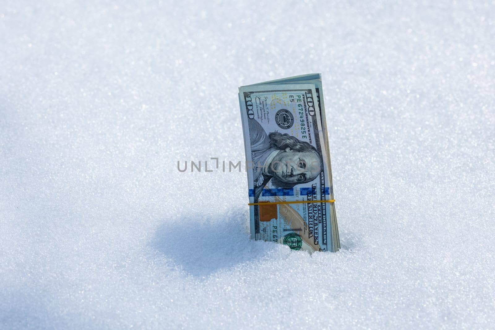 A bundle of cash lying on a snowy surface, vividly illustrating themes of financial waste and missed opportunities