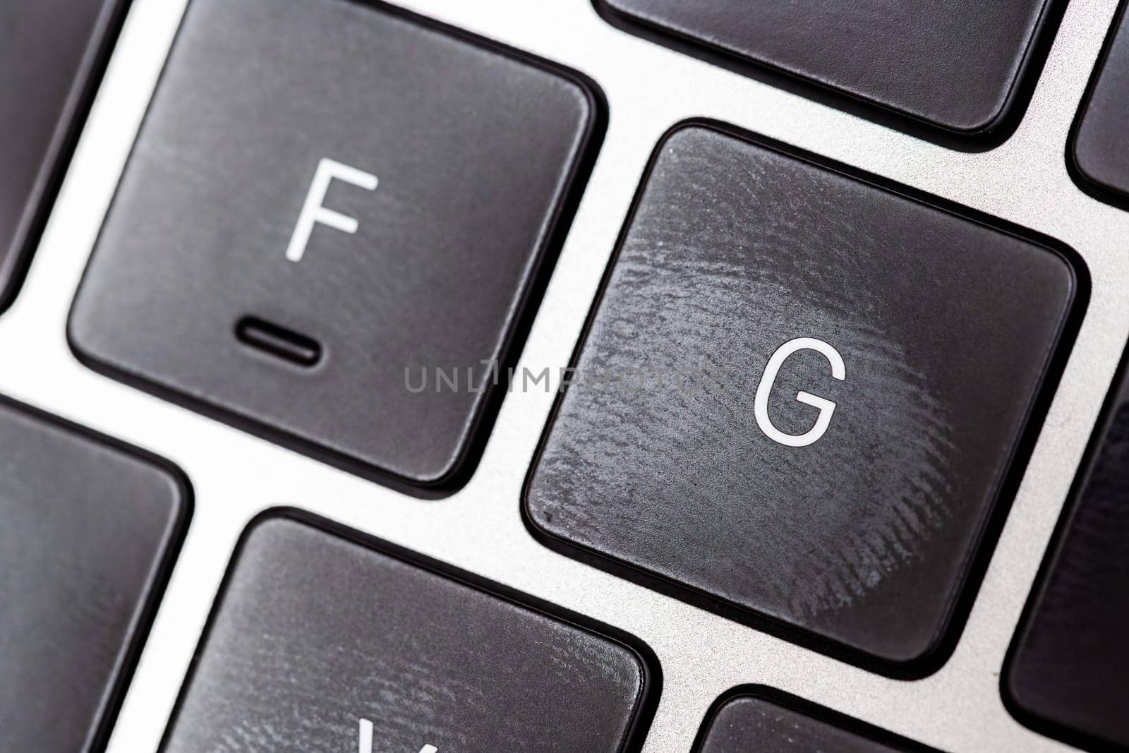 keyboard of famous silver colored laptop with fingerprints, closeup