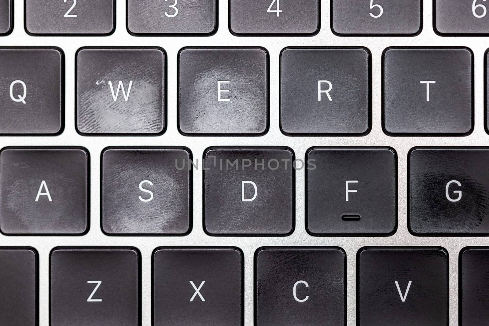 keyboard of famous silver colored laptop with fingerprints, closeup