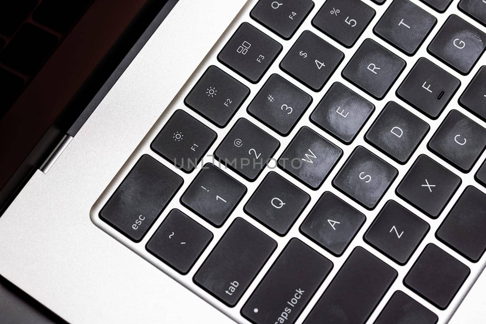 keyboard of famous silver colored laptop with fingerprints, closeup