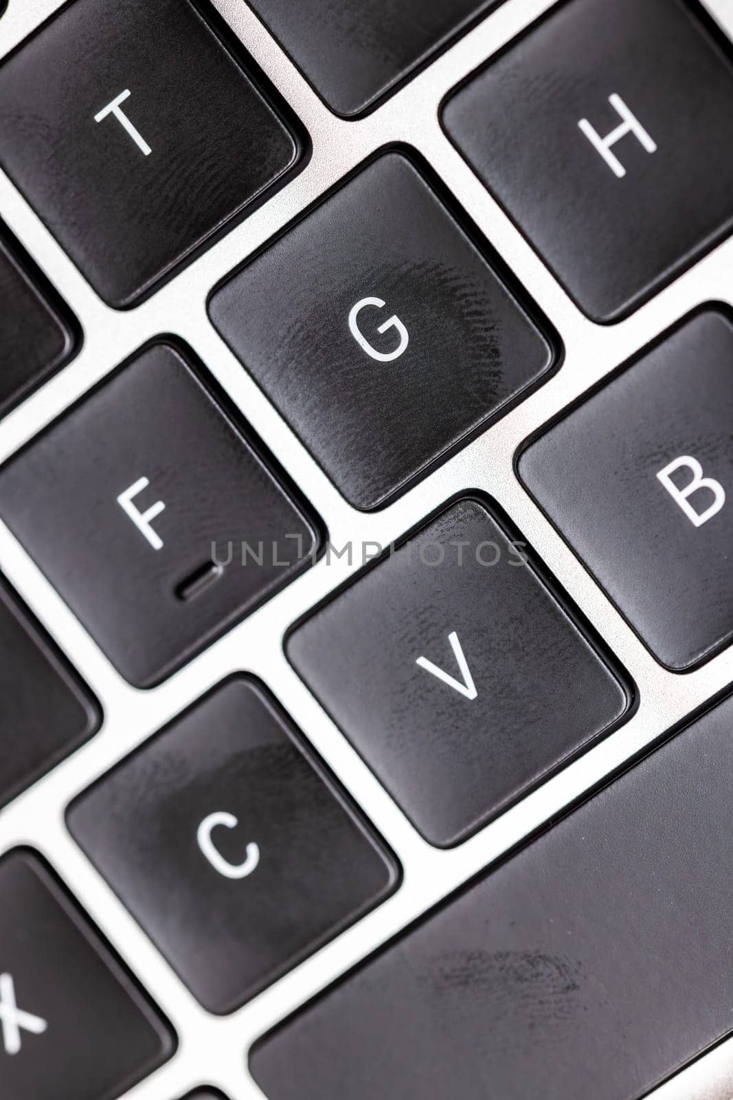 keyboard of famous silver colored laptop with fingerprints, closeup