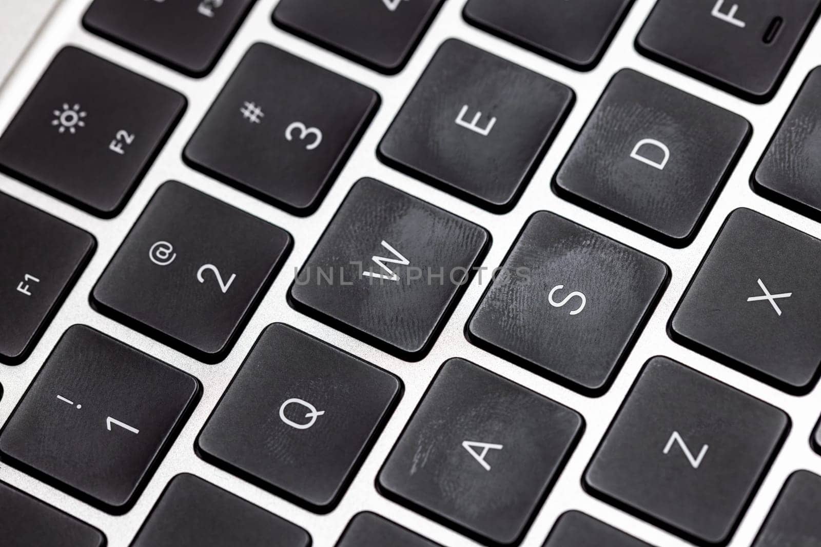 keyboard of famous silver colored laptop with fingerprints, closeup