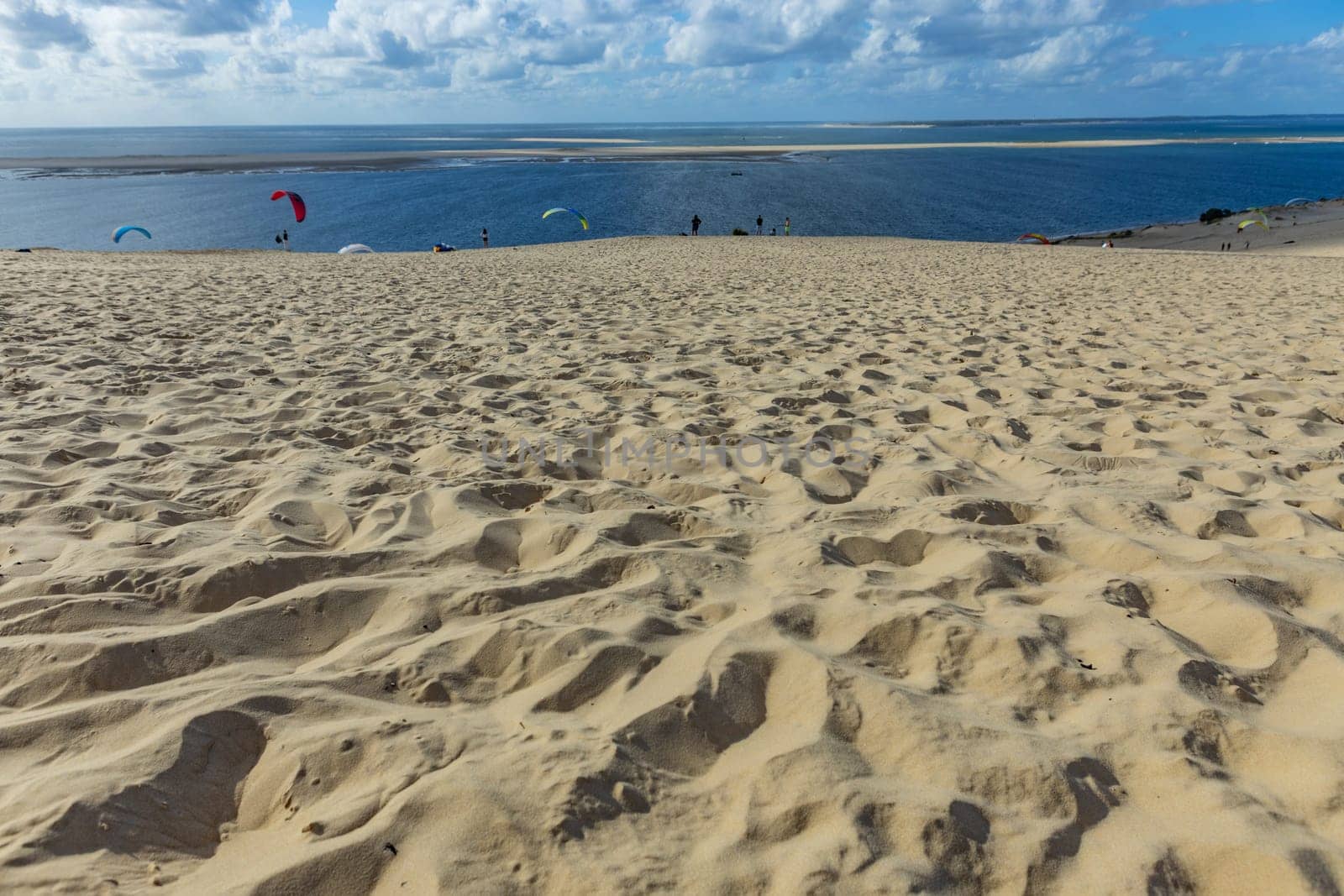 Dune of Pilat, France - August 14, 2024: People paragliding at the Great Dune of Pilat, Arcachon Basin, Nouvelle Aquitaine, France.