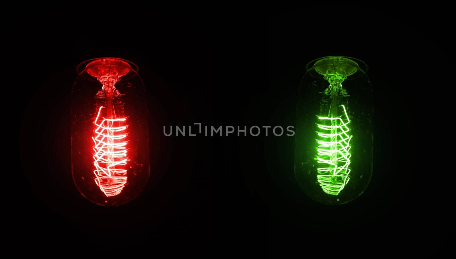 Retro looking light bulb glowing on dark background, bright wire visible in glass - red and green version, but colour can be changed with hue / saturation tool