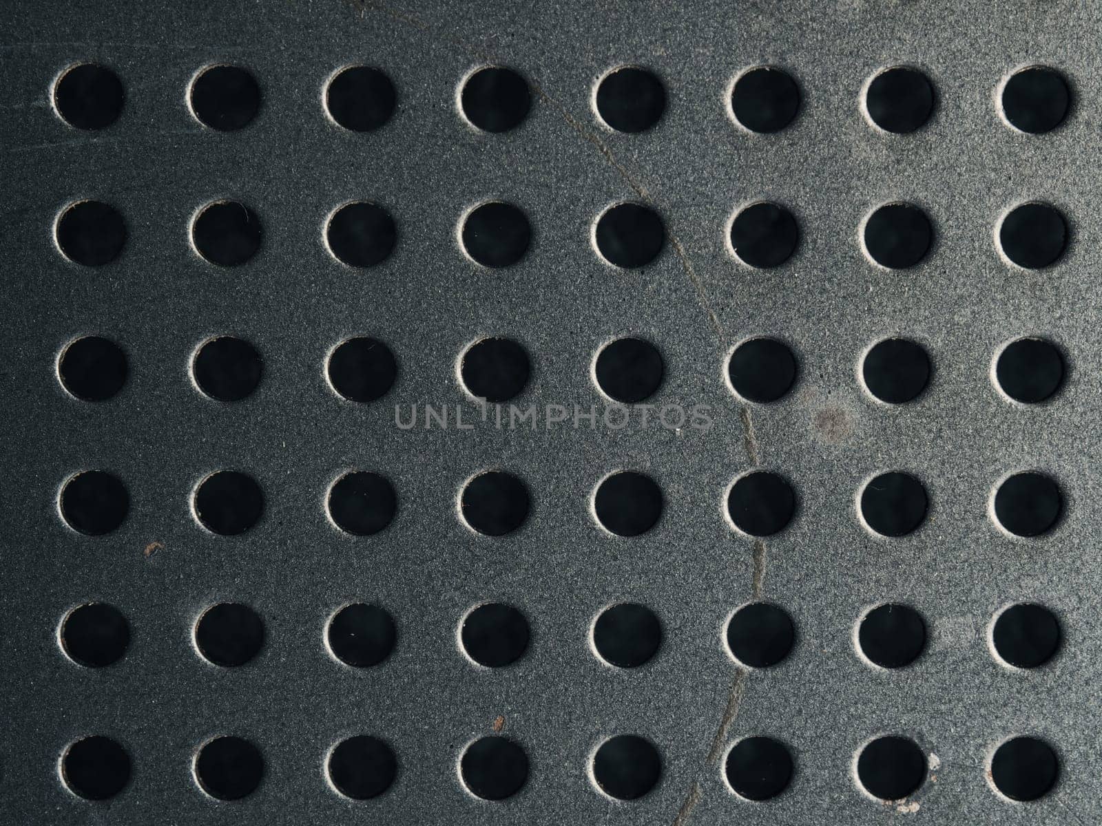 Anthracite steel or metal plate with dots or holes using as industrial background or header