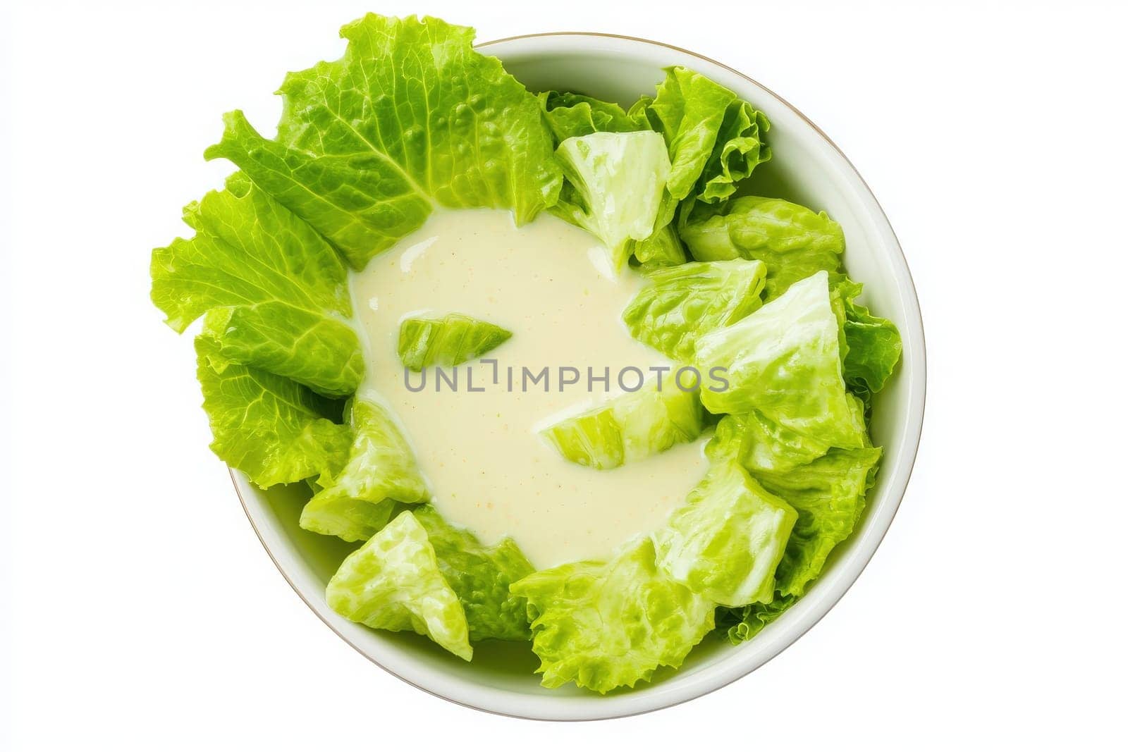 A creamy Caesar dressing is generously poured over fresh, cut romaine lettuce leaves in a bowl, creating an appetizing and vibrant salad ready to enjoy.