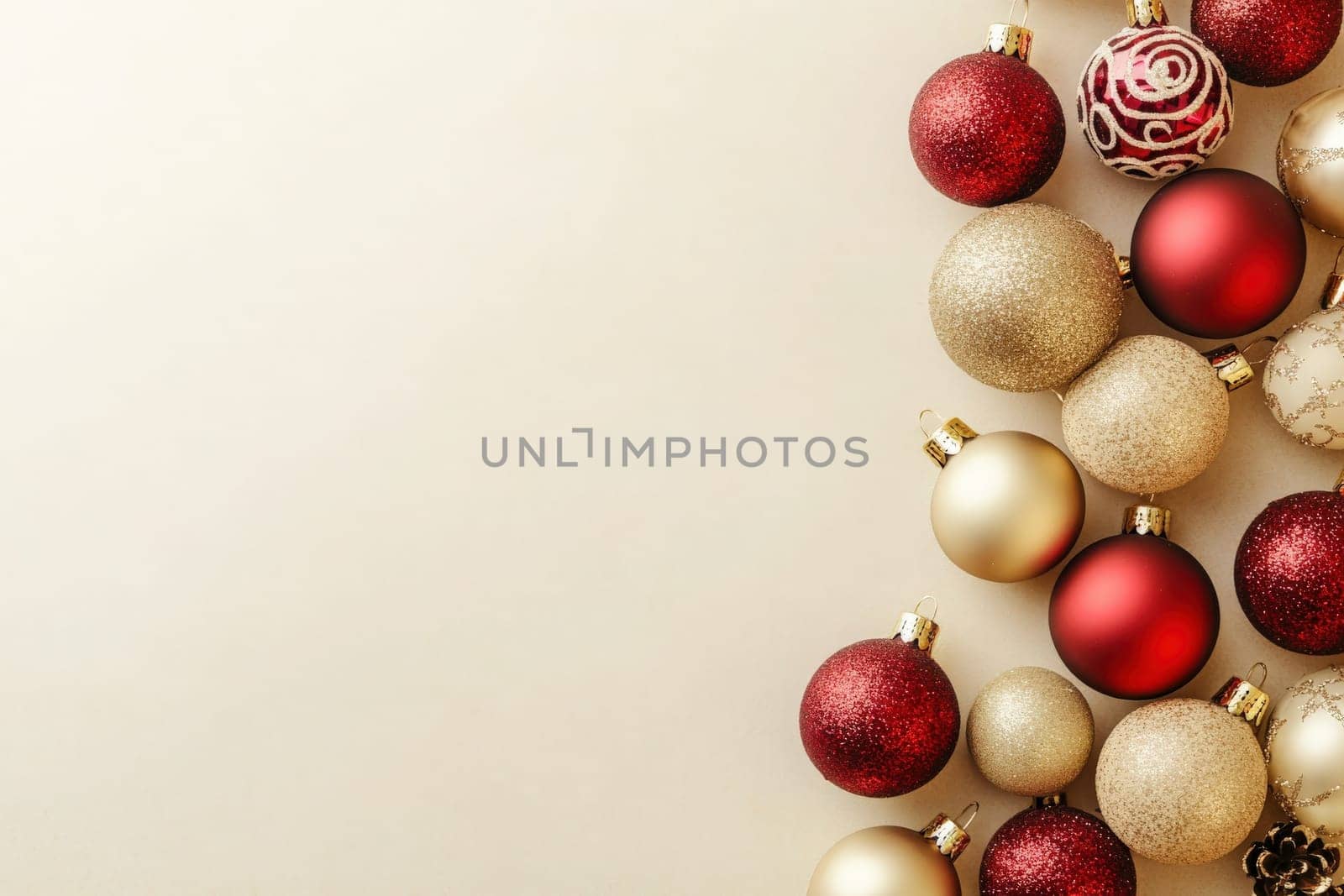 An assortment of colorful Christmas tree ornaments is elegantly placed on a solid, clean surface. The festive decorations add a warm touch, perfect for holiday celebrations.