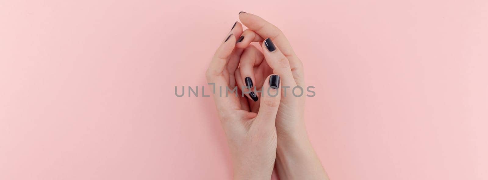 Stylish trendy female black manicure. Beautiful young woman's hands on millennial pink pastel background. Beauty and SPA concept. Banner Template for feminine blog social media