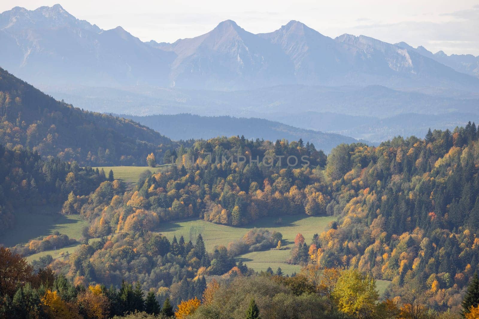Picturesque view of the autumn landscape in the Pieniny Mountains, colorful leaves on the trees, Szczawnica, Poland. It is time of polish golden autumn. Mountain range of Tatra Mountains in a distance