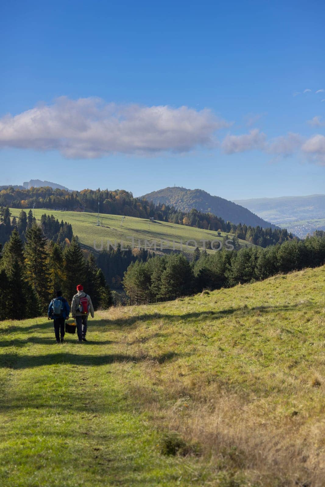 Szczawnica, Poland - October 12, 2024: Picturesque view of the autumn landscape in the Pieniny Mountains. Two tourists with a basket of mushrooms