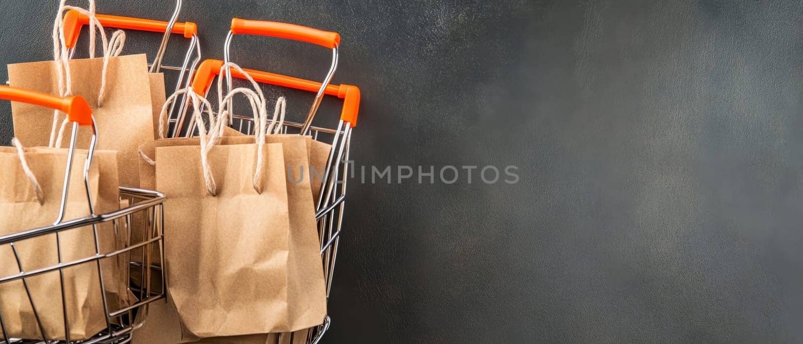 Multiple shopping carts filled with paper bags on a dark background, ideal for retail and commerce themes. Copy space available.