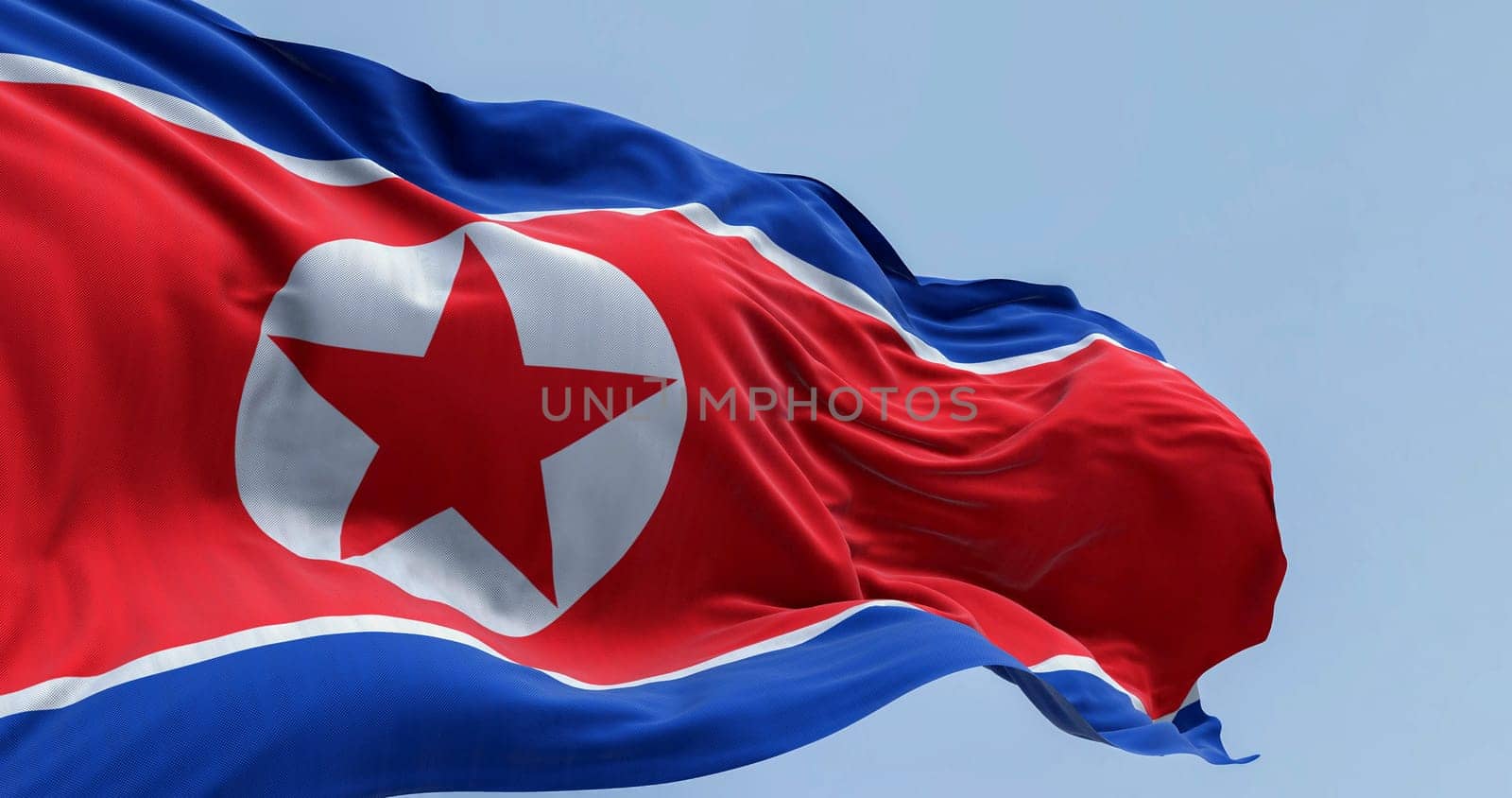 North Korea national flag waving in the wind on a clear day. Red flag with star and blue white stripes. 3d illustration render, Rippling fabric.