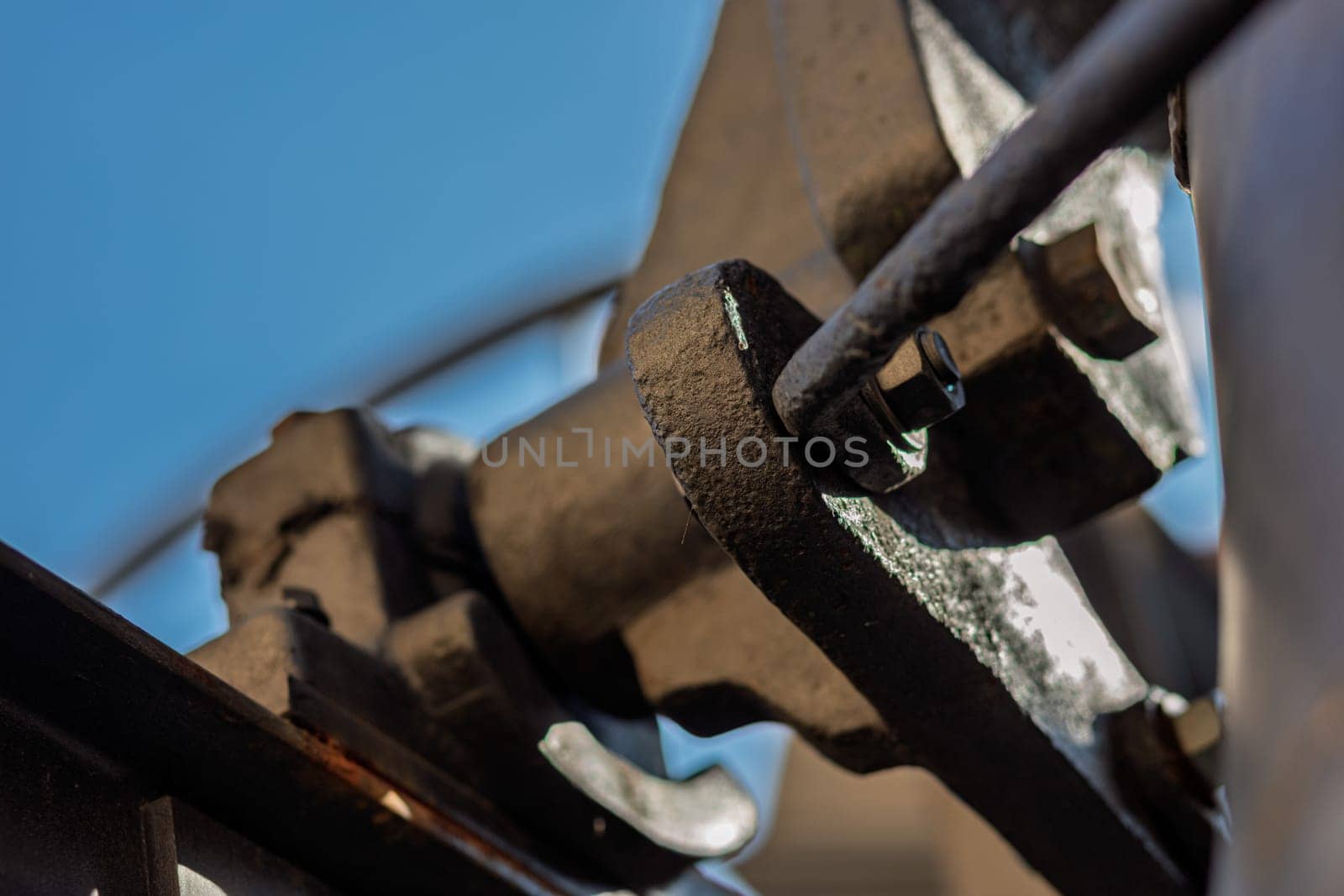 Close up of an old church bell mechanism, highlighting the craftsmanship and intricate details of welding and joining traditional metal parts