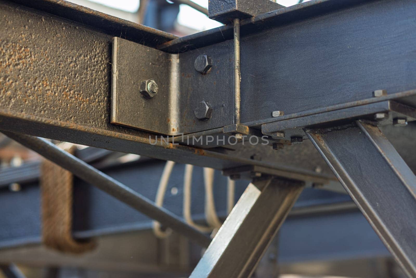 Bolting steel beams on a construction site, showcasing teamwork and progress in building projects. Intricate joint connections and welding create a visually captivating background