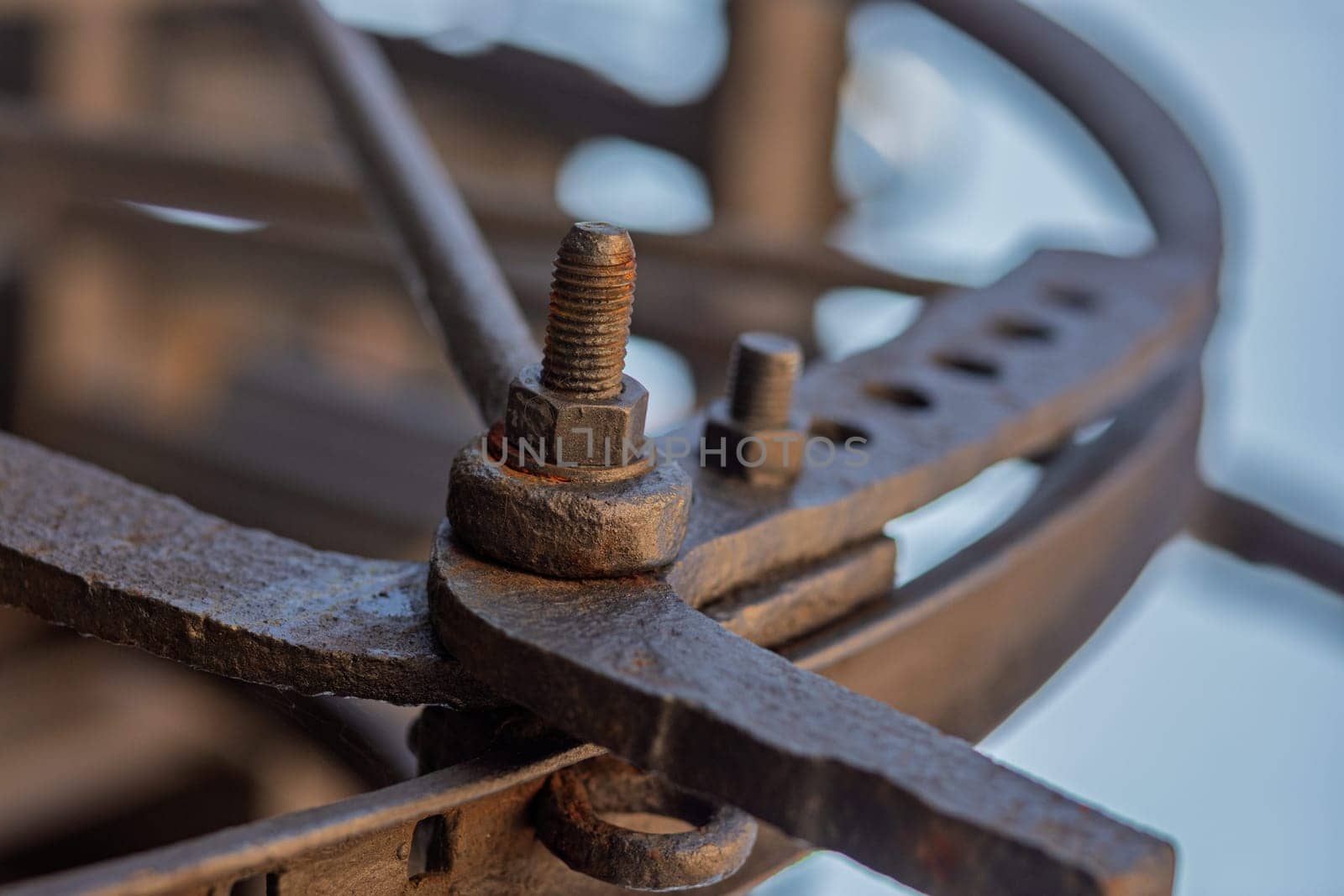Rusty bolt and nut connecting metal parts of an old mechanical device, showcasing craftsmanship and industrial heritage
